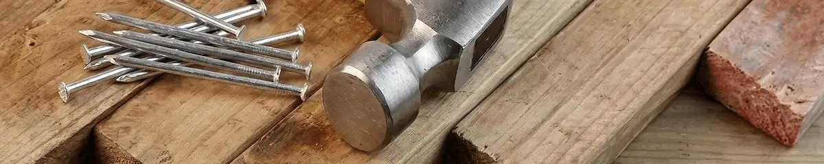 Hammer and nails on hardwood flooring boards in Des Moines, IA