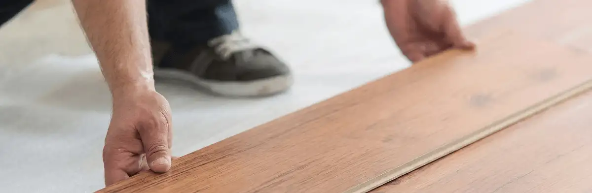 A professional installing laminate flooring in Des Moines, IA